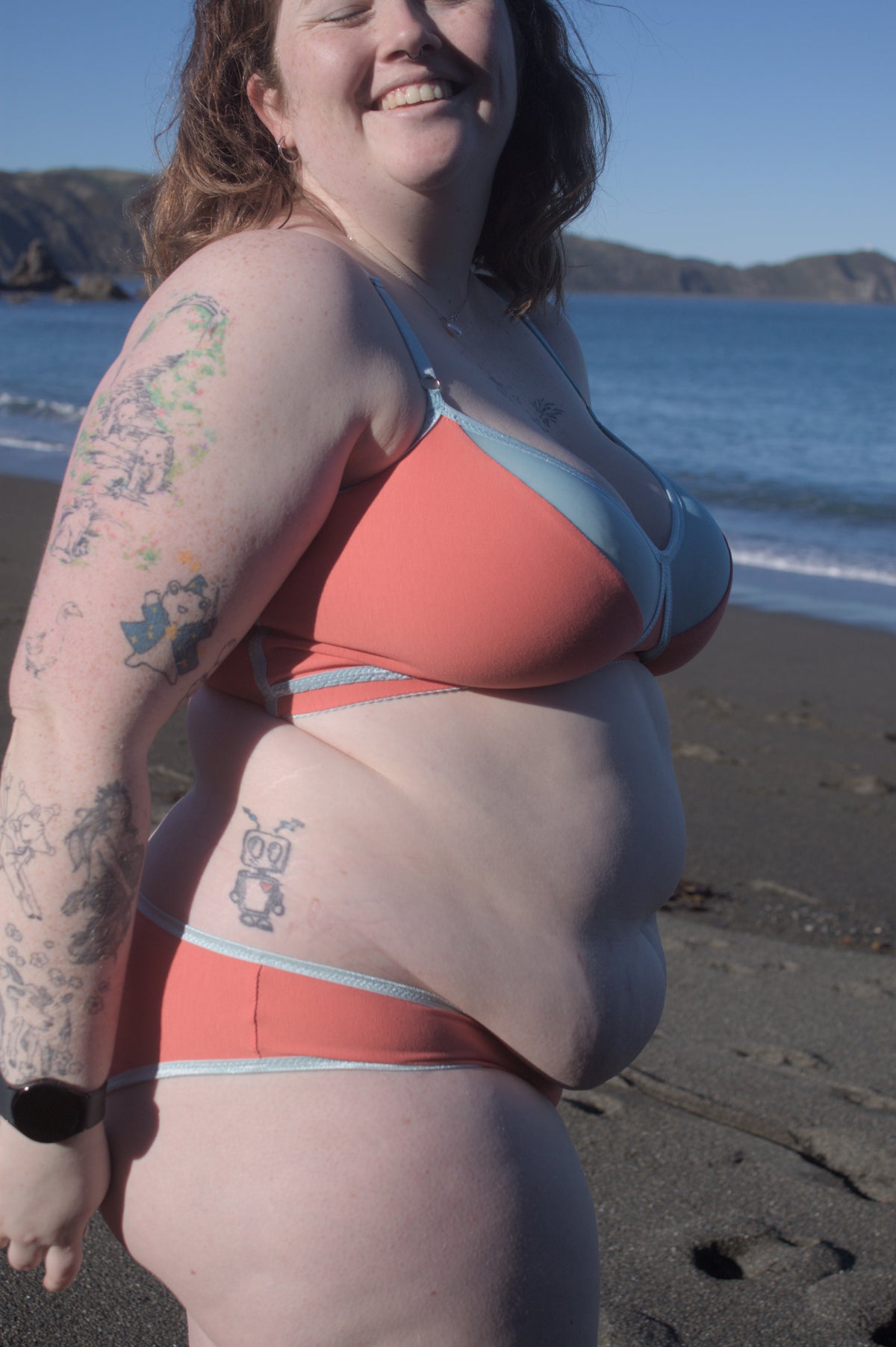 Person in comfy, supportive lingerie from Valerie Lingerie, standing outdoors in warm light with relaxed poise.