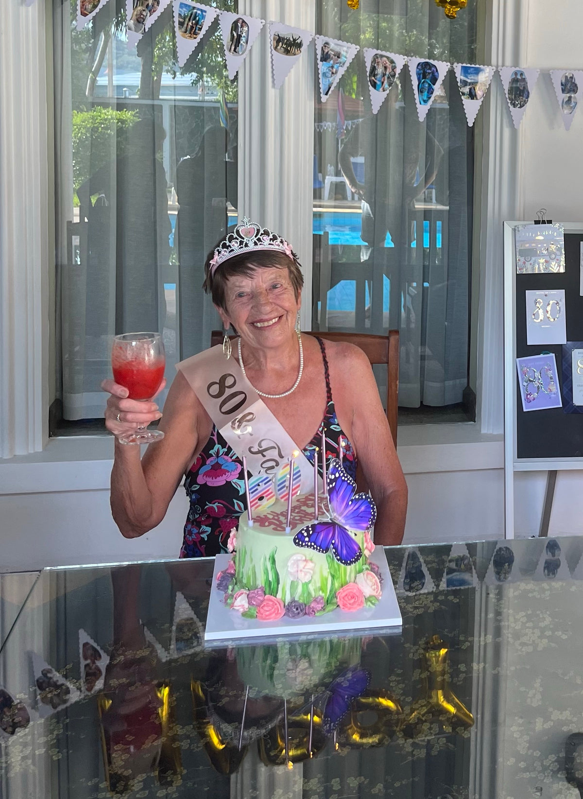 Rosie's gran Valerie celebrating her 80th birthday with a drink and a butterfly cake